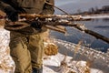 cropped male wearing warm clothes collecting dry wood for fire in forest on cold day