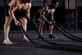 cropped Muscular men working out with heavy ropes. Photo of handsome sportsmen