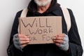 Cropped old-aged bearded bum in street wear with sigh for help