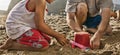 Cropped photo of boy and father building sand castle at beach