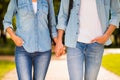 Cropped photo of charming pair holding hands wear denim outfit