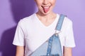 Cropped photo of childish funny young lady neck wear jeans overall showing tongue isolated violet color background