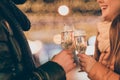 Cropped photo of couple celebrate x-mas christmas newyear clink cheers champagne glass outdoors wear season clothes