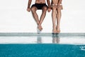 Cropped photo of couple sitting on pool edge Royalty Free Stock Photo