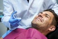 Dentist with a plastic teeth mold for his male patient