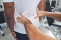 Experienced physical therapist palpating patient lower back