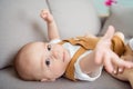 Cropped photo of excited curious adorable sweet son baby boy lay divan stretch hand wear suspenders home indoors Royalty Free Stock Photo