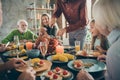 Cropped photo of full family sit feast dishes table near roasted turkey young father guy cutting meat slices hungry