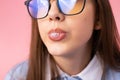 Cropped photo of funny school girl in glasses makes bubble gum wearing school uniform on pink background, school fun Royalty Free Stock Photo