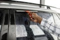 Cropped photo of hand of black man cleaning his car with a squeegee Royalty Free Stock Photo