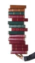 Cropped photo of a hand of a businessperson or lawer holding a stack of books.