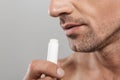 Cropped photo of of handsome mature man holding lip balm.