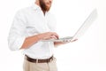 Cropped photo of handsome young bearded man using laptop. Royalty Free Stock Photo