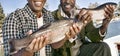 Cropped photo of happy father and son showing freshly caught fish Royalty Free Stock Photo