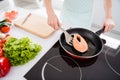 Cropped photo of housewife lady hands put fresh raw salmon fillet steak turning side lying frying pan cooking family Royalty Free Stock Photo