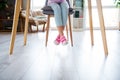 Cropped photo of little girl legs jeans sneakers ad sitting chair desktop bright modern interior house inside