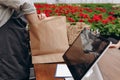 Cropped photo of male florist putting flowerpot in eco package. Selling plants in garden centre