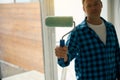 Cropped photo of man holding paint roller in hand