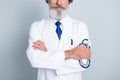 Cropped photo of mature doctor in coat holding stethoscope in his hand confident surgeon lab isolated over grey color Royalty Free Stock Photo