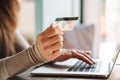 Cropped photo mature woman holding credit card while using on laptop