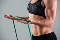 Cropped photo of musculary woman exercising with resistance band