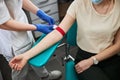 Phlebotomy technician tightening the elastic band on the patient arm Royalty Free Stock Photo