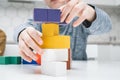 Cropped photo of preteen children friends sitting at table, building tower of colorful toy wooden construction blocks.