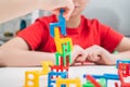 Cropped photo of preteen children playing board game stacking chairs, putting small chairs in stack for building tower. Royalty Free Stock Photo