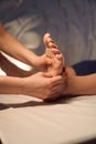 Experienced masseuse massaging client foot with hands