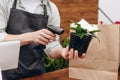 Cropped photo of saler scanning bar code of flowerpot. Flowers delivery service and sale of home plants in pots, wooden showcase