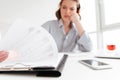 Cropped photo of serious brunette girl reading papers while siting at workplace in light aparment, selective focus on document Royalty Free Stock Photo