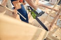 Experienced builder cutting construction wood with chainsaw Royalty Free Stock Photo