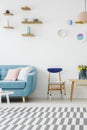 Cropped photo of a sofa, wooden chair, table, striped carpet and