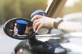 cropped photo of woman's hand holding blue paper cup of coffee in car. Hot drink take away. Travel with coffee Royalty Free Stock Photo