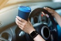 cropped photo of woman& x27;s hand holding blue paper cup of coffee in car. Hot drink take away. Travel with coffee Royalty Free Stock Photo