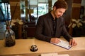 Cropped photo of young businessman filling registration form at hotel Royalty Free Stock Photo