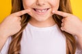 Cropped photo of young little girl happy positive smile point fingers teeth cavity stomatology over yellow