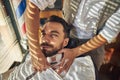 Brunette man receiving a clean shave from barber