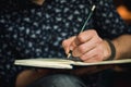 Man writing in journal with a pencil Royalty Free Stock Photo