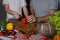 Cropped portrait of father and kid's hands cutting red bell pepper