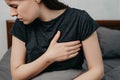 Cropped portrait of sad worried girl suffers from heartache sitting on bed at home Royalty Free Stock Photo