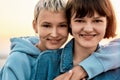 Cropped portrait of two attractive young women with short hair smiling at camera, Young lesbian couple spending time Royalty Free Stock Photo