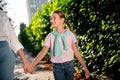 Cropped portrait of two peaceful positive people hold arms walk enjoy pastime chill downtown park outdoors