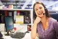 Answering your call with a smile. Cropped portrait of a young businesswoman wearing a headset at her desk. Royalty Free Stock Photo