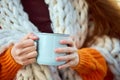 Cropped portrait of young girl covered blanket holding warming hot cup of coffee, tea or hot chocolate. Autumn mood. Royalty Free Stock Photo