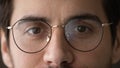 Cropped portrait of young man wearing glasses looking at camera