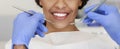 Cropped of pretty female smile and dentist hands