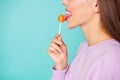 Cropped profile photo of funny lady hold lollipop hand sweets addicted person lick tasty candy tongue wear violet