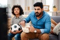 Were both avid sports fans. Cropped shot of an adorable little boy watching a football game with his father on tv at