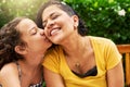 Kisses for mom. Cropped shot of an adorable little girl kissing her mother on the cheek while in the park. Royalty Free Stock Photo